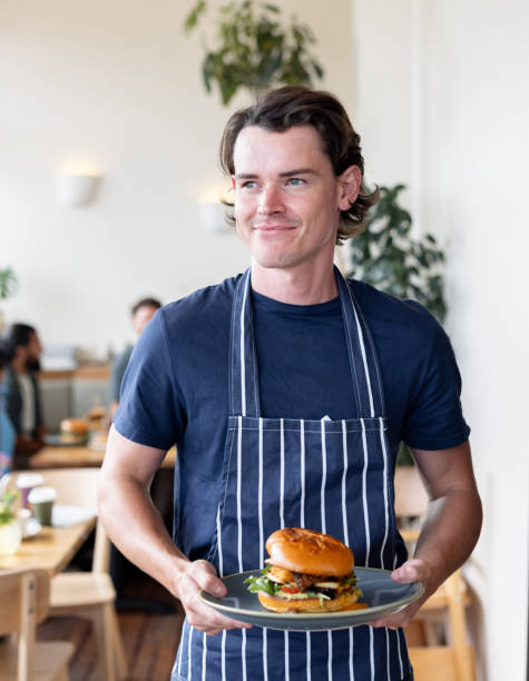 istock Happy waiter serving food at a restaurant 2196076686