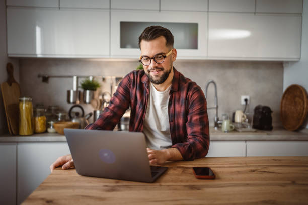 istock adult man with beard work on his laptop computer at kitchen happy 2196079035