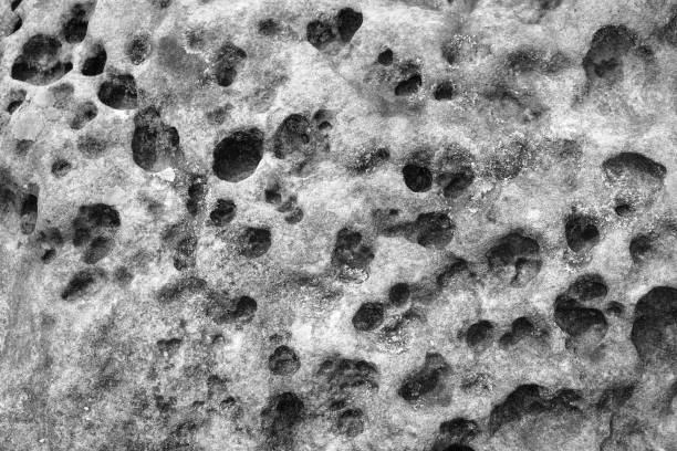 istock Black and white stone wall background.Grey rock with holes and potholes on surface. Monochrome abstract pattern. Rock texture backdrop. Element, material design. Close up. 2196079099