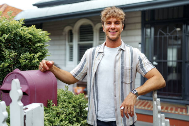 istock Cheerful handsome man posing for camera while standing in front of his house 2196080686