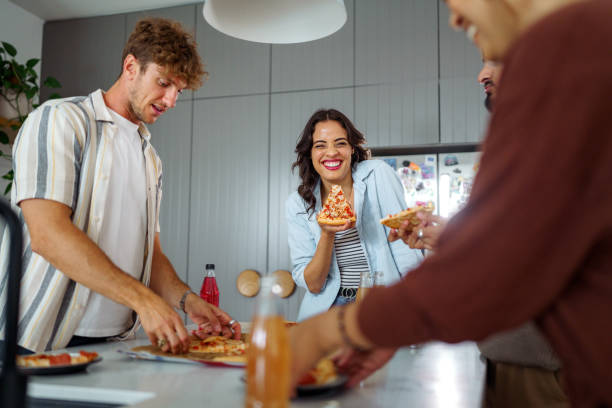 istock Young cheerful friends enjoying pizza at home 2196080764
