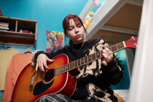 istock Gen Z Girl Learning How To Play Guitar 2196080838
