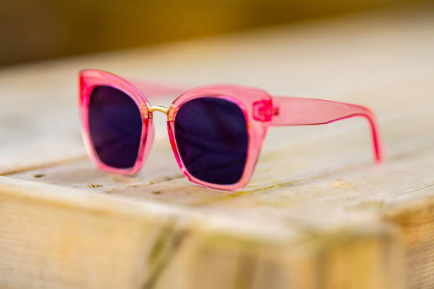 istock Pink sunglasses on a wooden table.. 2196081579