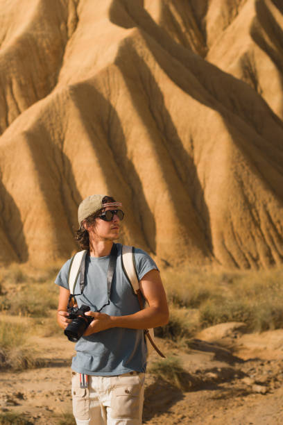 istock A photographer carrying a camera and backpack is captivated by the dramatic sandstone formations of Bardenas Reales. The arid beauty and unique textures define this natural landmark. 2196084090
