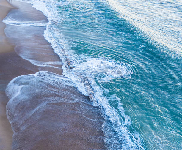 istock Swirls in the surf left by the waves 2196085366