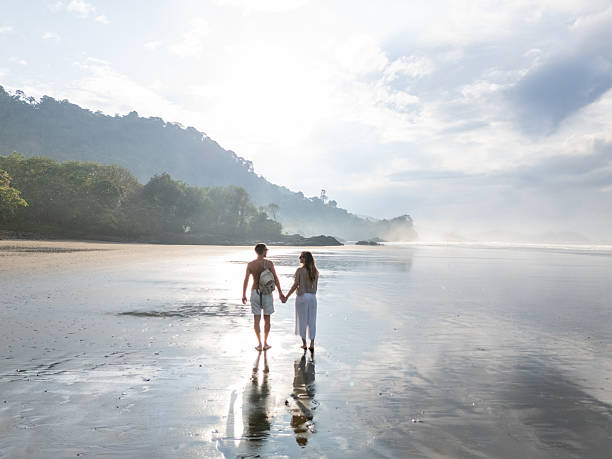 istock Couple Walking on Scenic Beach at Sunrise 2196086133