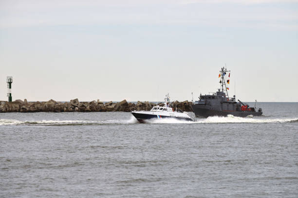 istock Coast guard ship escort russian warship that has trespassed state border along seaside 2196087735