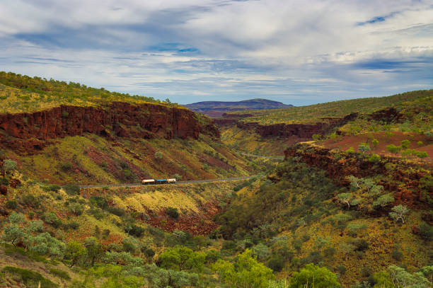 Road train in a spectacular canyon in the Australian outback Road train on the Great Northern Highway in Karijini National Park, Western Australia. The highway winds through the spectacular Munjina Gorge barron gorge national park stock pictures, royalty-free photos & images