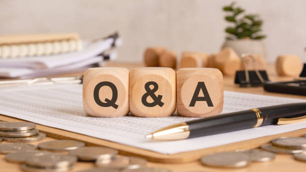 istock wooden blocks with QA text on a financial document, surrounded by coins, a pen, and office supplies 2196091736
