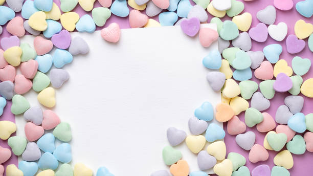 istock Pastel candy conversation hearts Valentine's Day background with blank white card. One heart with word Maybe. 2196092367