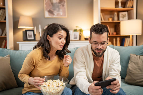 istock Couple having fun with mobile games on the sofa 2196096988