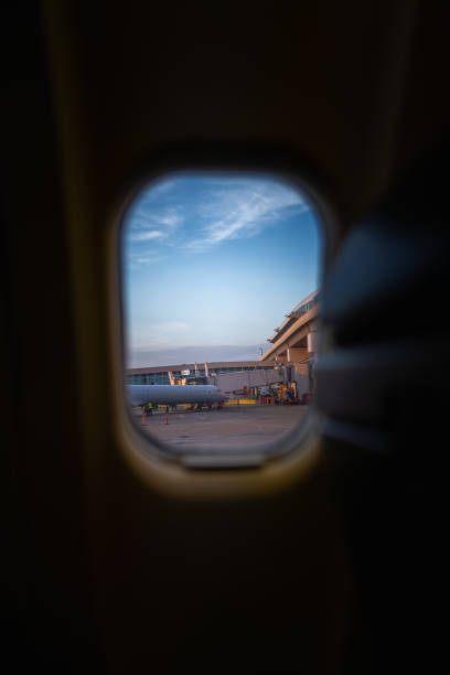Shot of an unidentifiable traveler using his smartphone in an empty airport lounge