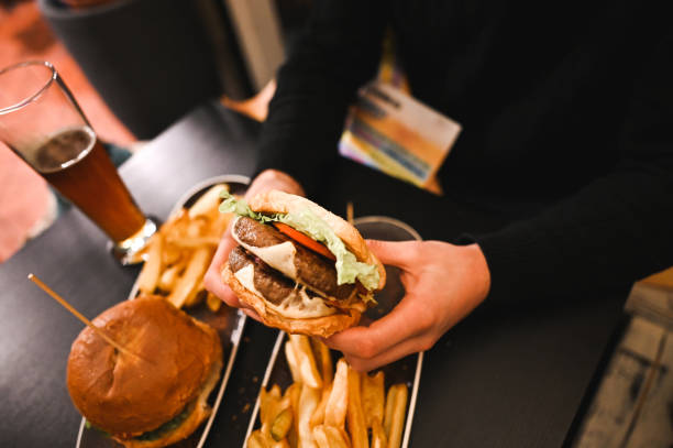 istock Man eating burger at restaurant close up. 2196100824