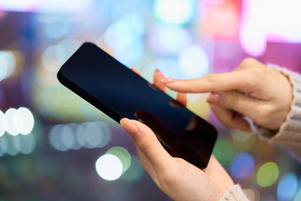 istock Hands operating a smartphone in a busy downtown area 2196102584