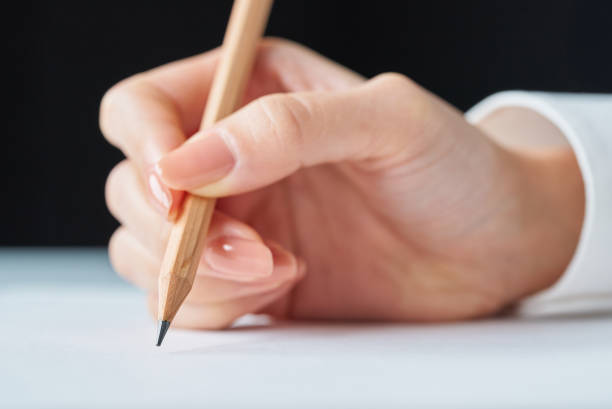 Hand holding a pencil and blank paper