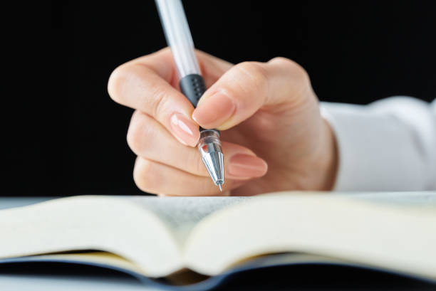 a person studying with a text and pen