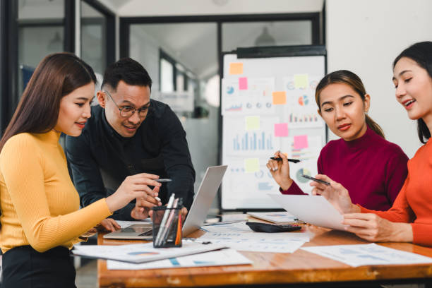 istock Collaborative team meeting with four professionals discussing data analysis and strategies. Engaged expressions and modern workspace enhance productivity 2196110478