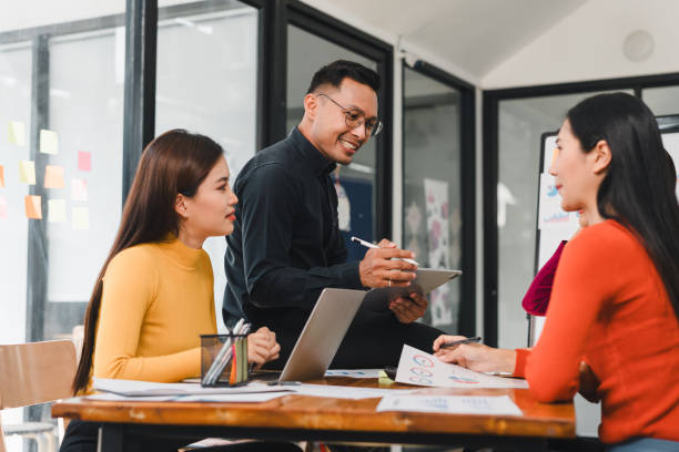 istock Collaborative business meeting with three professionals discussing ideas, using laptop and tablet, in modern office space. atmosphere is focused and productive 2196110624