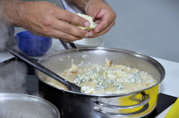 Cooking pear risotto with gorgonzola in a stainless steel pan