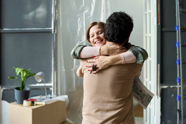 istock Woman with key embracing her husband 2196112638