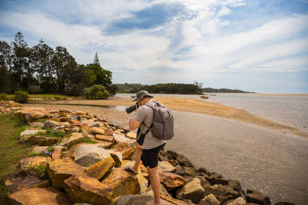 Side view of a man taking photos by Nambucca River, Nambucca Heads, NSW, Australia