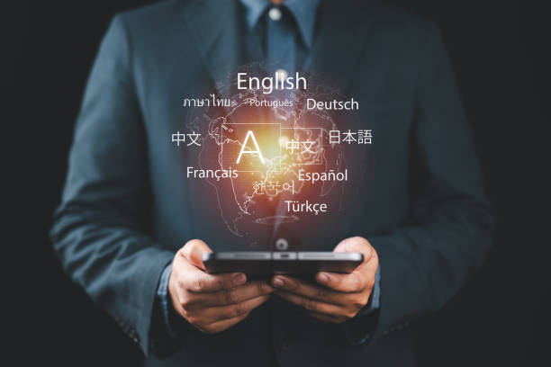 istock Multilingual Language Translation Technology Concept. A person holding holographic globe with speech bubbles and various languages, represents global language translate and multilingual communication. 2196114070