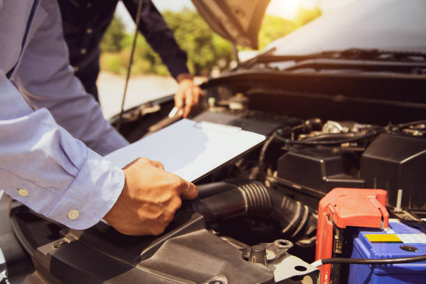 istock Auto mechanic using checklist for car engine systems after fixed. concepts of car insurance support and services. 2196116754