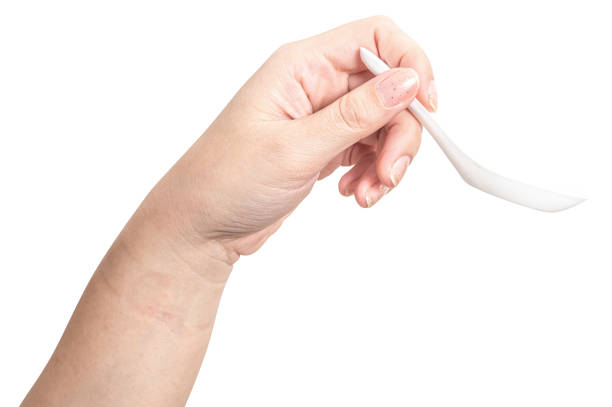 istock Female hand holding a white plastic spoon isolated on white background. 2196116898