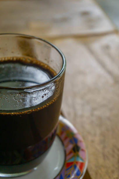 a cup of dark coffee on wooden table