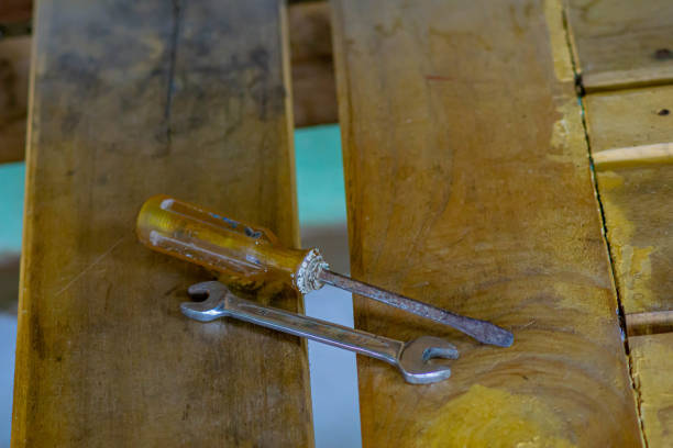 screwdriver and wrench on wooden background