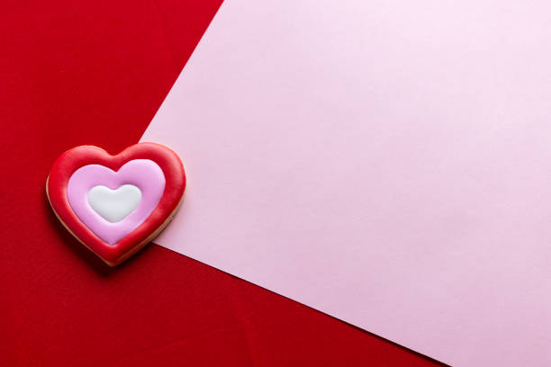 Handmade heart-shaped cookie with red, pink and white colors.
