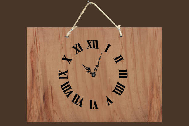 Wooden clock with roman numerals hanging on a wall