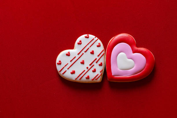 Handmade heart-shaped cookie with red, pink and white colors.