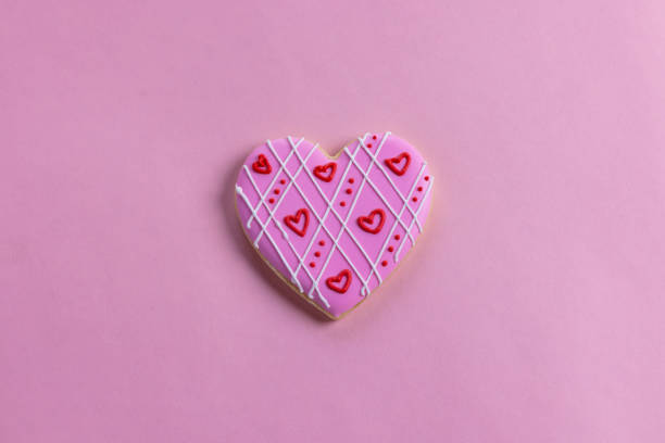 Handmade heart-shaped cookie with red, pink and white colors.