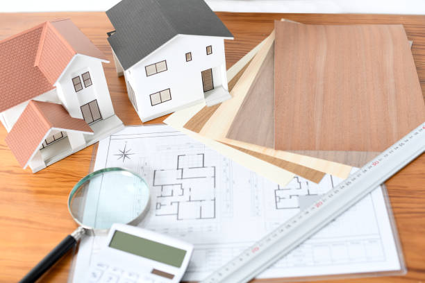 istock A desk lined with architectural models, tile and flooring samples, and a calculator. 2196120388