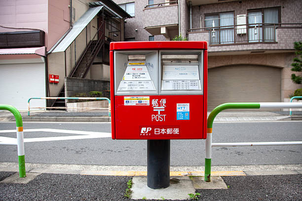 Tokyo, Japan - November 16, 2024.\nA Japan Post mailbox on a Tokyo street sidewalk in Japan.