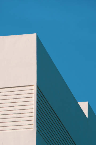 istock a minimalist white building facade against a vibrant blue sky, highlighting clean lines and geometric design elements. 2196126080