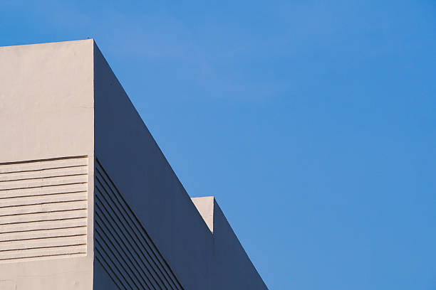 istock a contemporary building facade with clean, minimalistic lines set against a blue sky, emphasizing symmetry and architectural texture. 2196126083