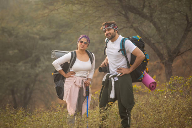 istock Tired young couple with backpacks standing in forest 2196128548
