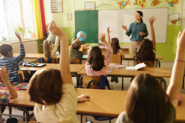 istock Rear view of students know the teacher's question at elementary school. 2196132709