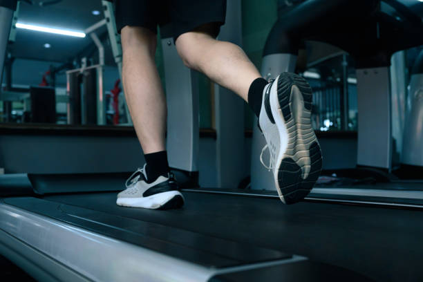 istock Close up of unrecognizable man walking or jogging on a treadmill 2196134411