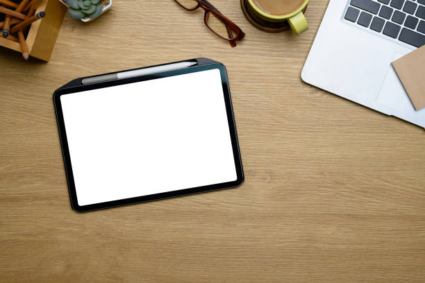 istock Modern creative workspace with digital tablet, coffee cup, glasses and stationery on wooden desk 2196134541