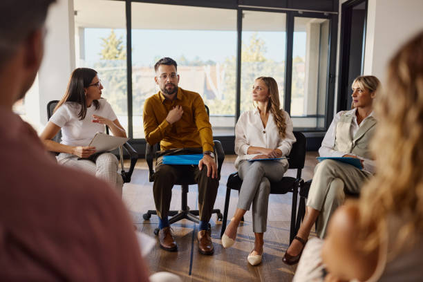 istock Worried businessman talking on a group therapy in the office. 2196136397