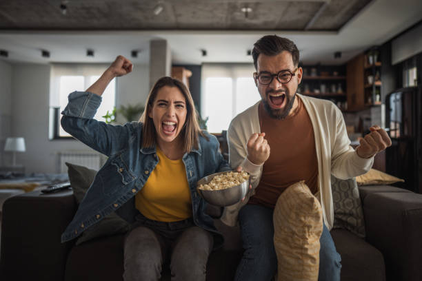 istock Happy couple watching a match and celebrating together 2196137261