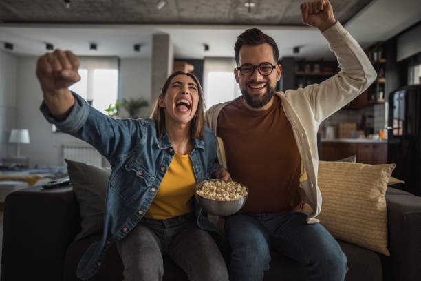 istock Happy couple watching a match and celebrating together 2196137304