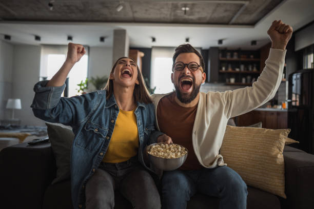 istock Happy couple watching a match and celebrating together 2196137307