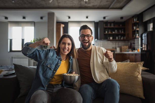 istock Happy couple watching a match and celebrating together 2196137430