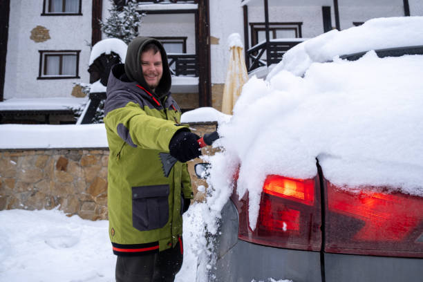 istock Person Clearing Snow from Car in Winter Landscape 2196140311
