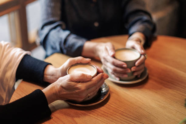 Senior women holding cappuccino cups in cafe