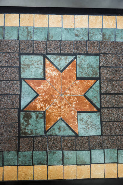 A captivating mosaic design showcases a star pattern created with earthy tones and bold colors, highlighting the intricate craftsmanship on the tiled surface.
